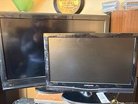 Front view of both TVs showing relative sizes and brands