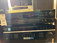 Front view of Denon cassette deck stacked above Sony control center