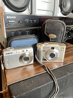 Front view of both digital cameras and their cases