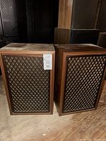 Front view of both Sansui speakers showing cabinets and grilles