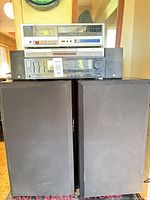 Full view of both floor speakers with stacked receiver, DVD player and cassette deck