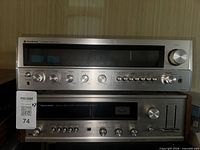 Front view of both receivers stacked, showing brand logos and control layouts