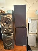 Left stack shows two Denon speakers with curved fronts and three drivers each