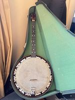 Full banjo in open green-lined case