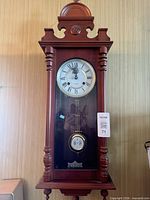Front view of wooden pendulum wall clock