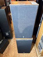 Pair of Yamaha speakers stacked showing front grills and wood cabinets