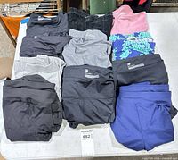 Tabletop view of all eleven folded leggings various colors
