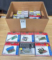 Box with multiple sealed Velleman kits, eight displayed outside