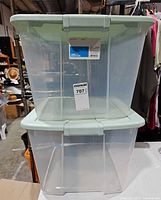 Front view of two stacked clear plastic totes showing transparency and lid color