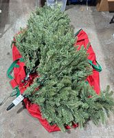 Tree sections with attached lights resting on red storage bag