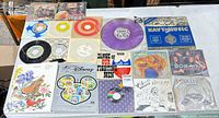 Full table view showing mixture of vinyl records, stamp books and CD