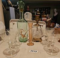 Group shot showing all items: decanter, lamp, four glasses, bud vase