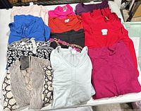 All 12 folded tops arranged on table