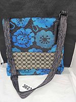 Front view showing floral design, contrast pocket, strap