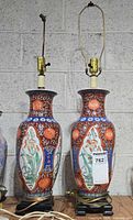 Front view of both matching porcelain lamps showing floral Imari decoration and bases