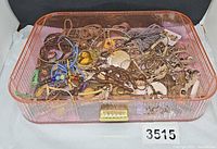 Overview of pink acrylic jewelry box filled with assorted costume jewelry