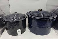 Two speckled enamel stock pots side by side showing size difference