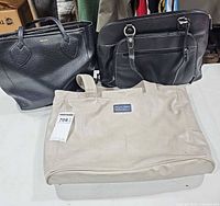 Front view of three bags: beige Golla, black Anne Klein, black Franklin Covey