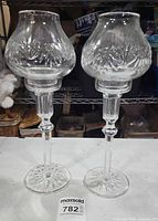 Two assembled Waterford crystal candlesticks with globes standing on table