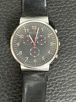 Front view of watch showing dial, hands, numerals, leather strap