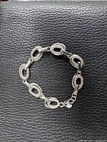 Full bracelet coiled on black leather surface