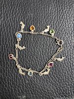 Full view of sterling silver bracelet with dolphin charms and coloured stones