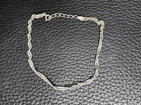 Full view of silver twisted link chain bracelet laid flat