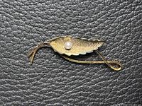 Front view of textured leaf brooch with pearl