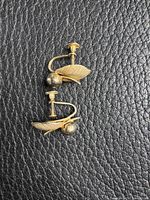 Both earrings front view on textured background