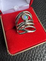 Front view of sterling silver ring showing openwork bands and opal cabochon