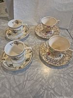 Four demitasse cups with four saucers, two distinct patterns visible