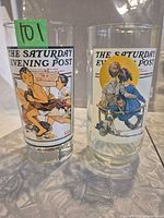 Two Saturday Evening Post tumblers standing upright showing both designs
