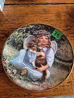 Front of porcelain plate with angel illustration and gold rim