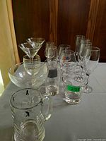 Group view of assorted stemware, tumblers and beer mug on table