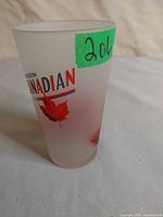 Side view of frosted Molson Canadian pint glass showing logo and maple leaf graphic