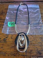 Full view of necklace showing pendant design, cord, and clasp