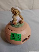 Top view showing bear figurine on lid and side opening of terracotta holder