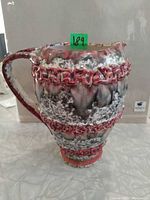 Full side view of pitcher showing glaze pattern, relief band and form