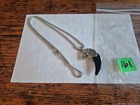 Full view of silvertone chain and eagle head blackstone claw pendant