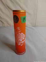 Full view of orange glass vase showing floral pattern and shape