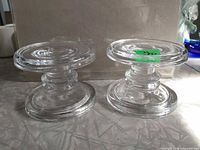 Side view of two clear glass spool candle holders