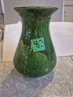 Front view of green handmade pottery vase with flared rim