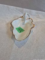 Top view showing leaf shape, white glaze, gold edging, green lot sticker