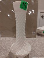 Full view of white milk glass vase showing diamond pattern and height