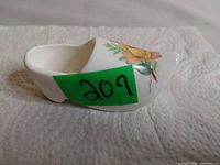 Right side view of miniature bone china clog with floral motif and lot sticker visible