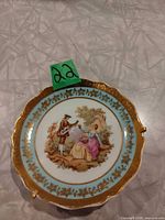 Front of miniature Limoges plate showing design and gilt rim