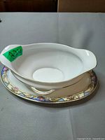 Oblique view showing gravy boat attached to underplate, pattern and gold trim visible