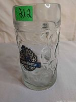 Front view of clear dimpled glass mug with Steam Whistle logo