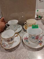 All four teacup and saucer sets grouped