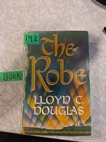 Front cover of paperback showing title and author, spine damage visible